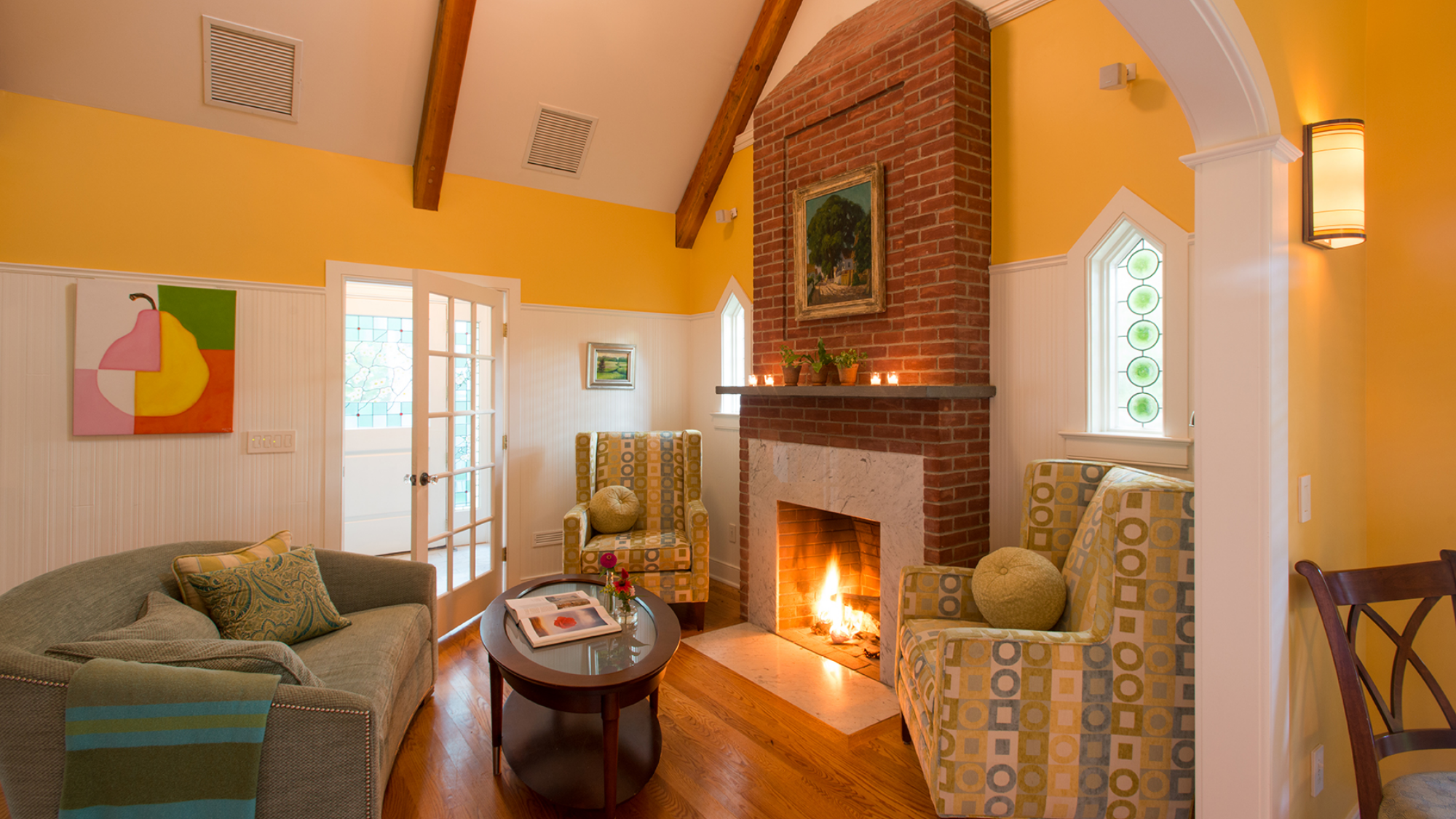 Cozy living room with a fireplace and bright yellow walls at Winvian Farm.