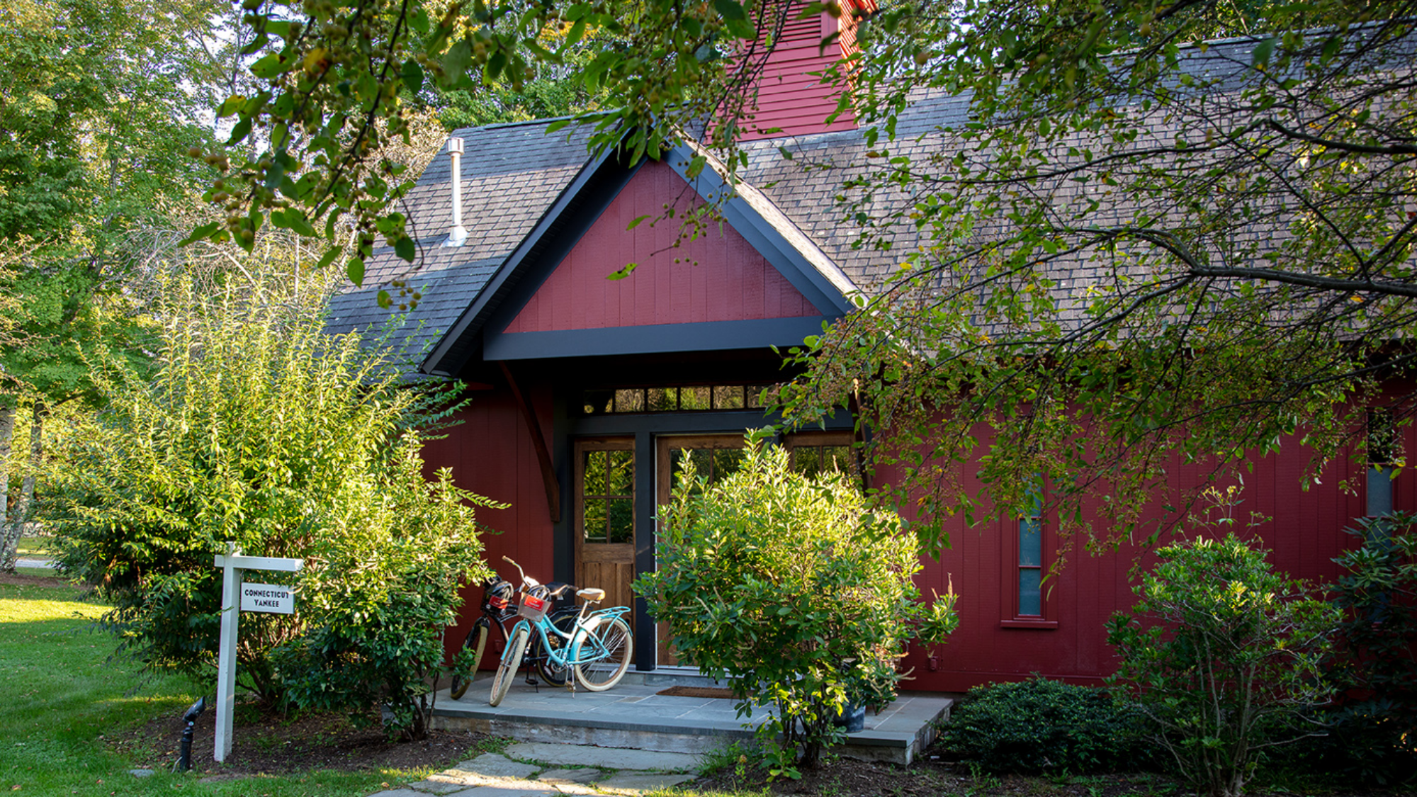 Exterior of the Connecticut Yankee Cottage at Winvian Farm with bicycles on the porch.
