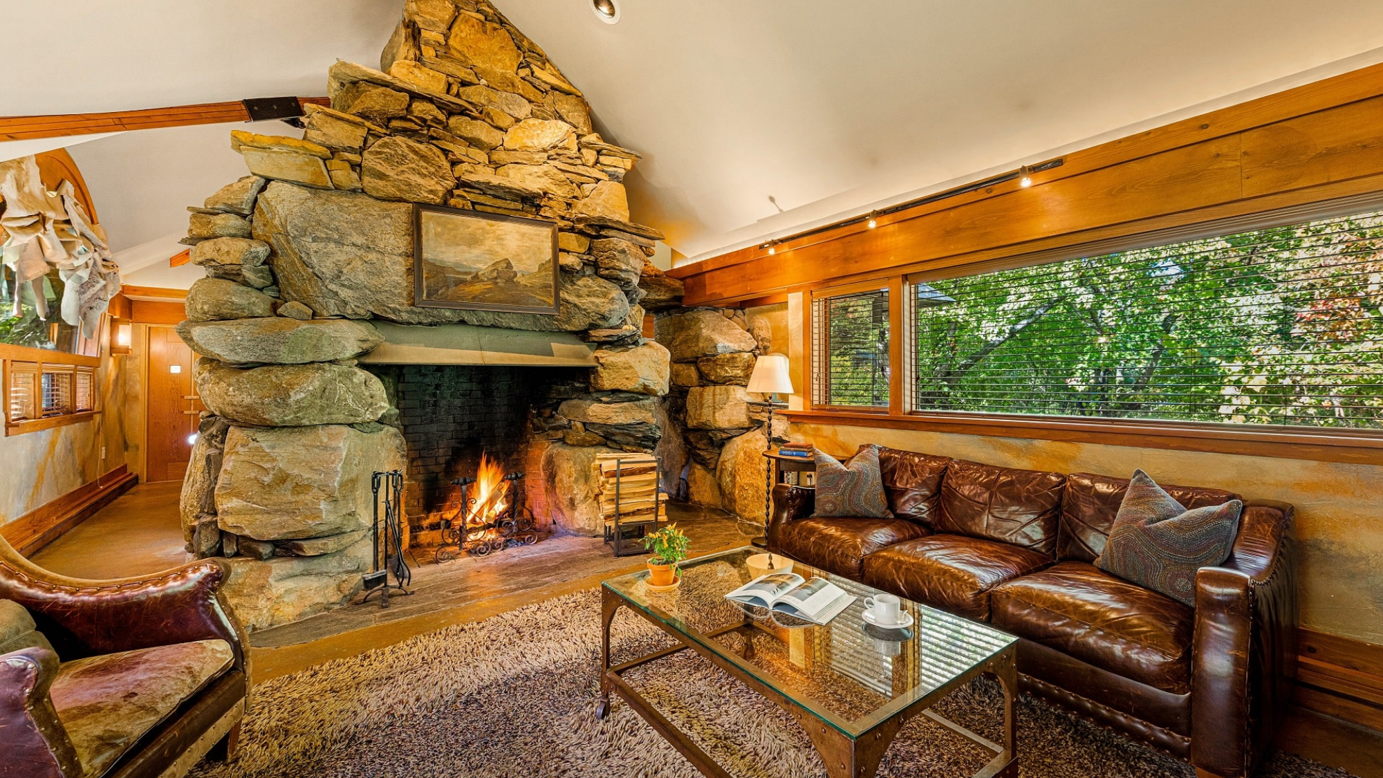 Cozy living room in the Stone Cottage at Winvian Farm with a large stone fireplace.