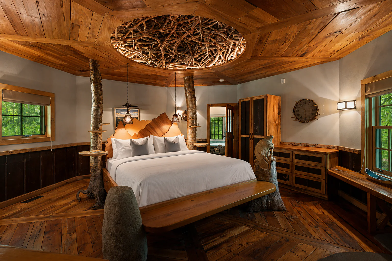 Rustic bedroom with wooden ceiling, tree trunks as bed posts, white bedding, and large windows overlooking greenery. Warm, natural tones throughout.