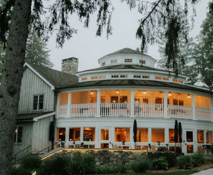Exterior view of the 1775 House with its circular balcony and warm lights at Winvian Farm.