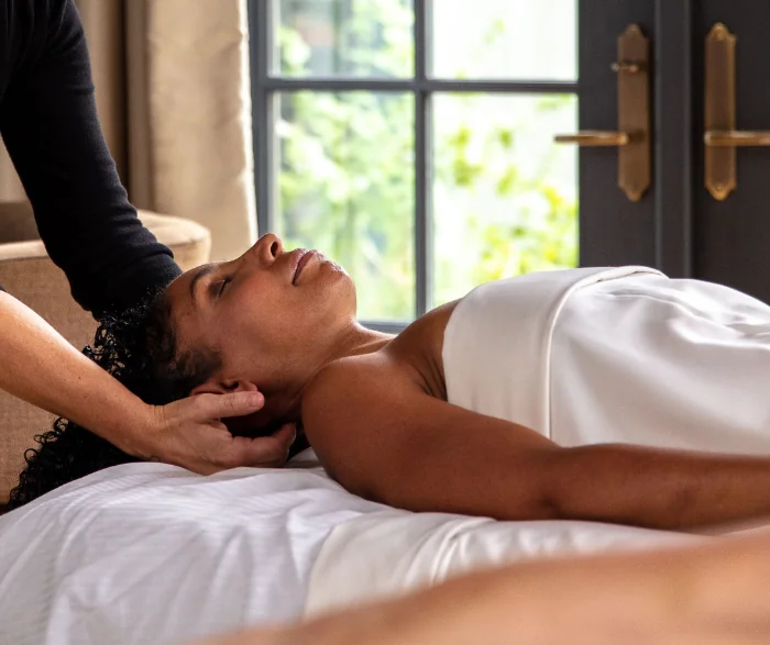 Person receiving a relaxing neck massage while lying on a spa bed