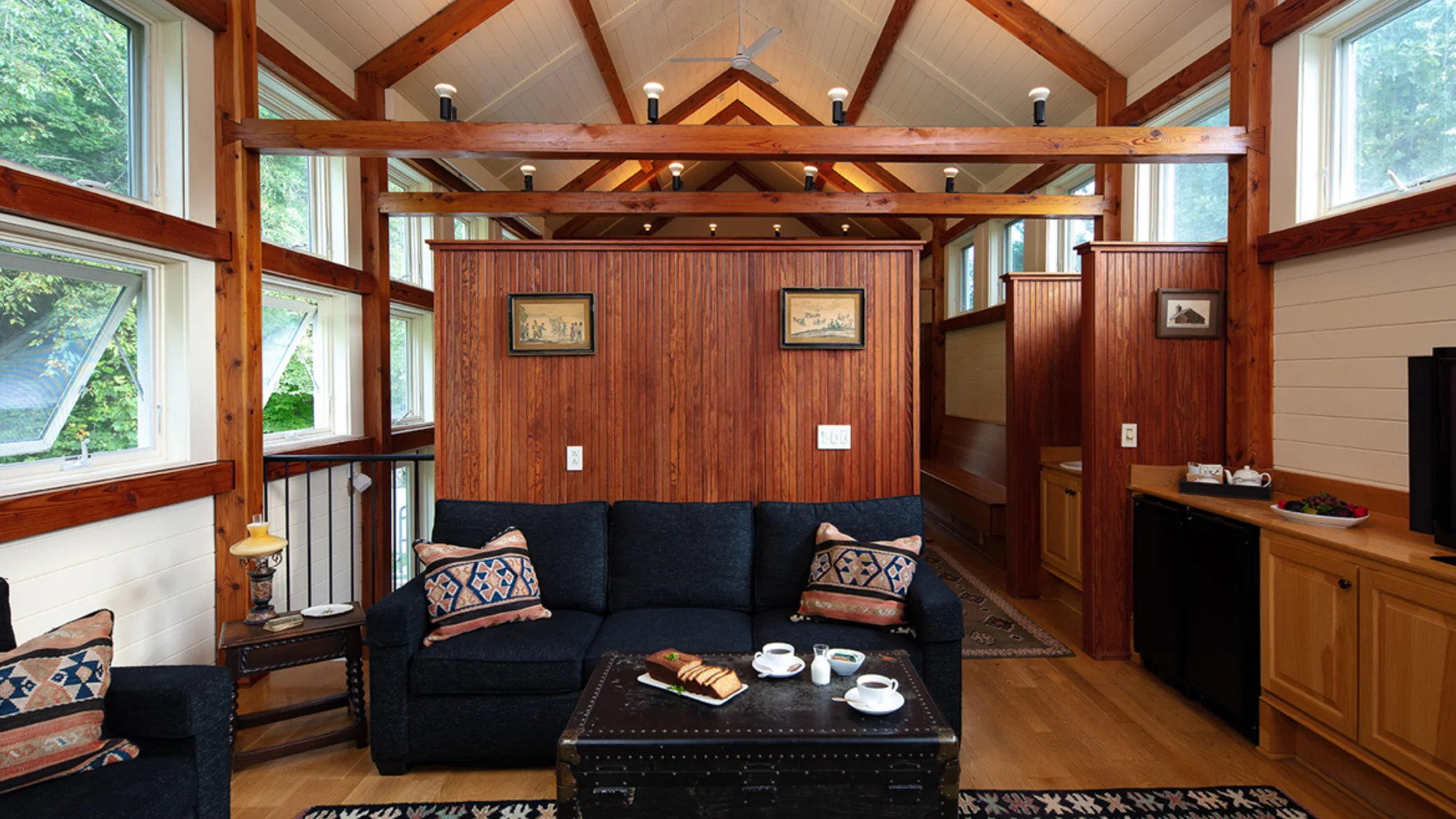 Cozy living area in the Cottages at Winvian Farm with a blue sofa and wooden beams.