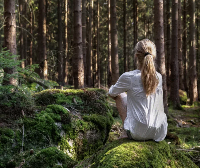 Girl in a white shirt enjoying fresh air in a forest